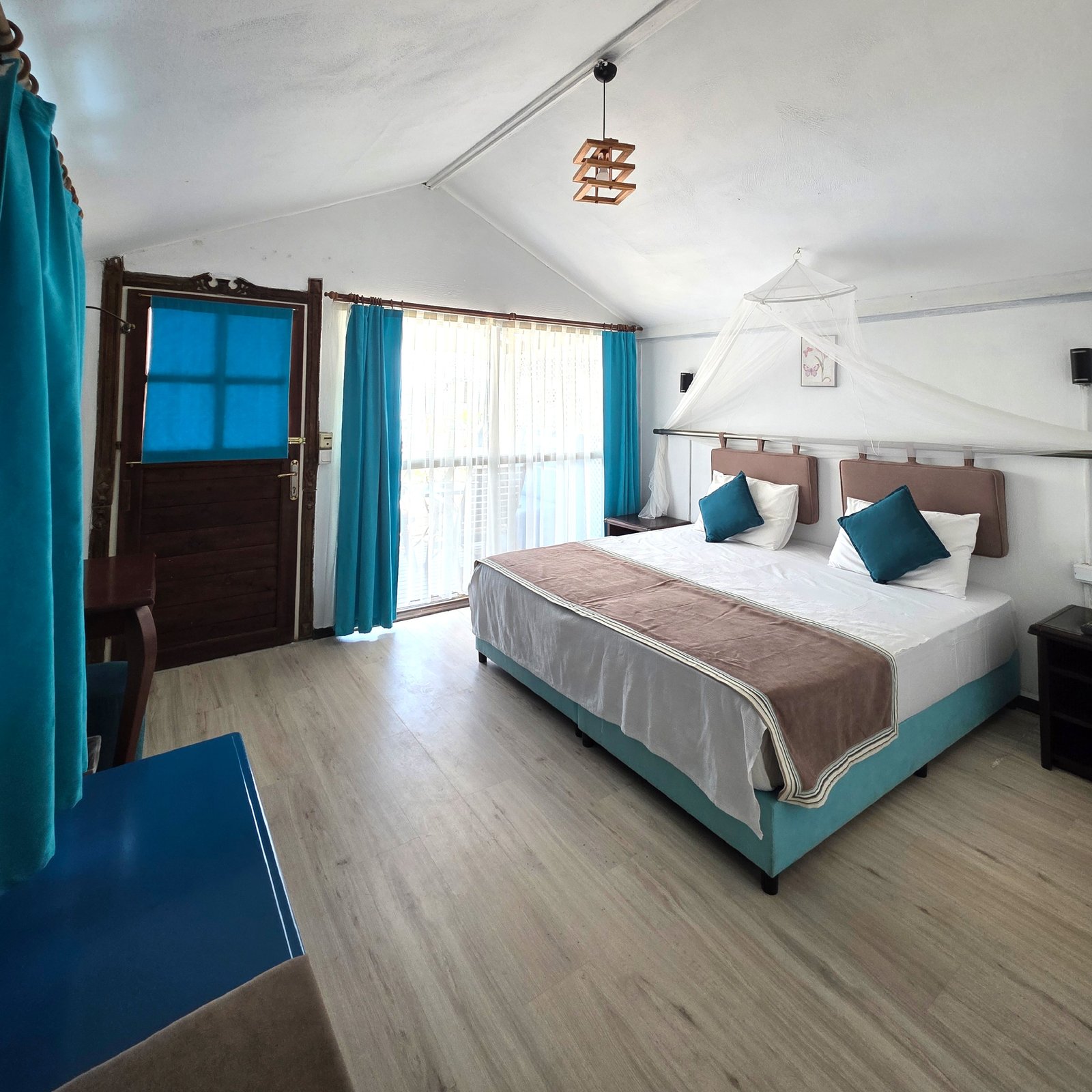 Blu Brezza classic suite with turquoise curtains and double bed